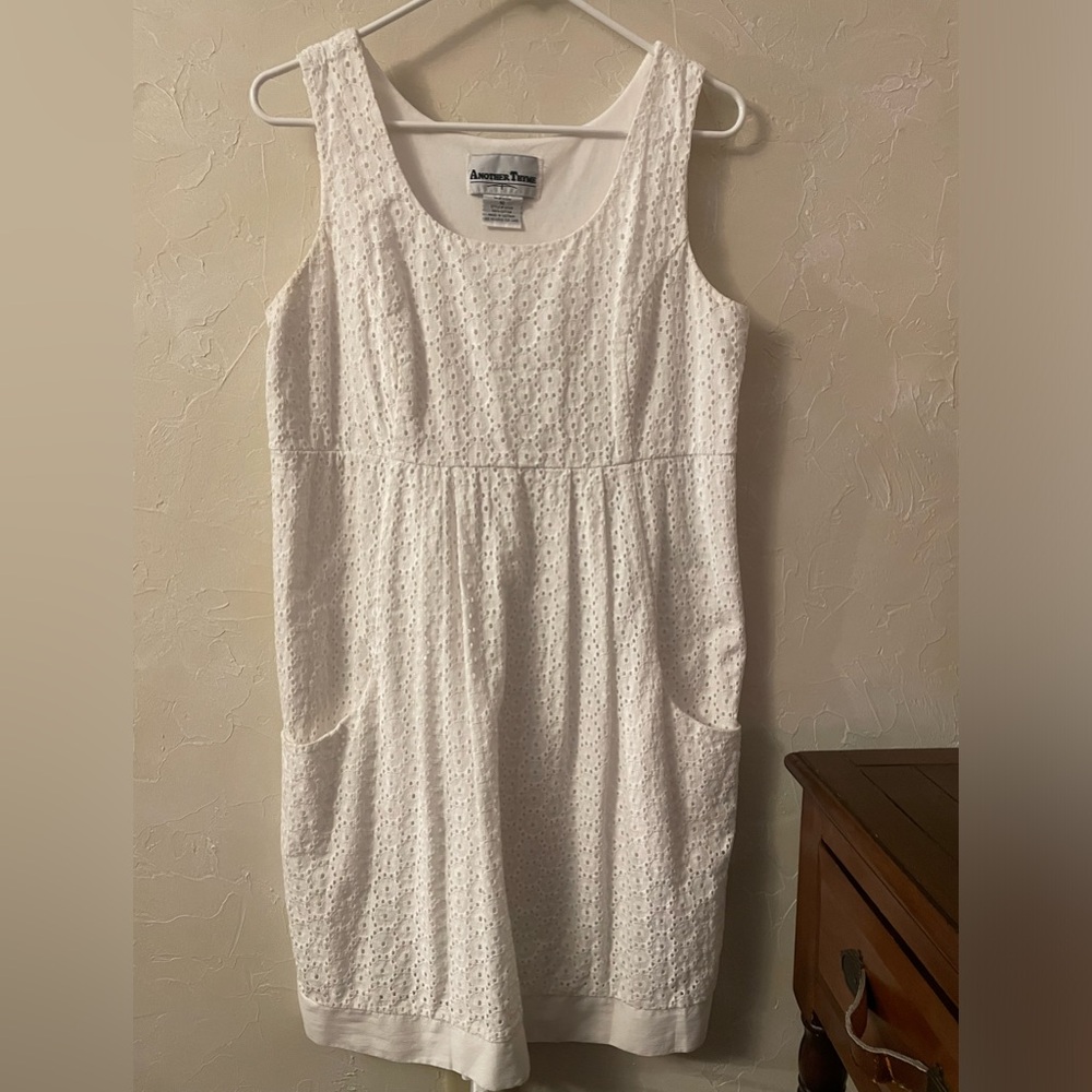 White eyelet summer dress with pockets. Empire waist,knee length. Good used